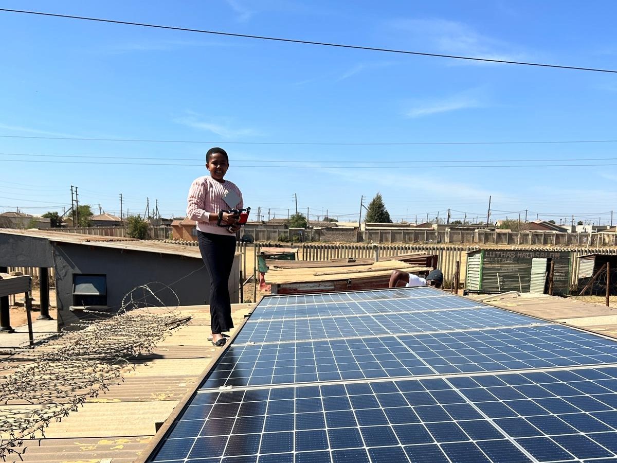 A community member installing solar panels on a rooftop